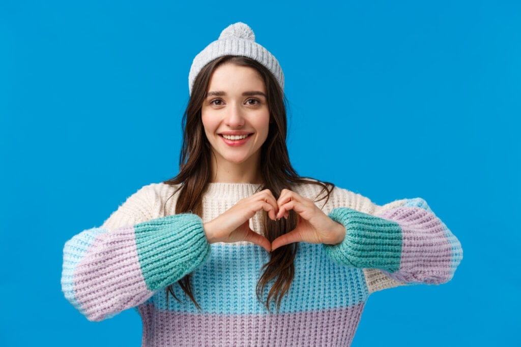 Valentines day relationship and emotions concept Lovely pretty brunette girl in winter hat sweater showing heart sign and smiling looking camera happy show love and affection blue background Acceptance Path boundaries in relationships
acceptance path