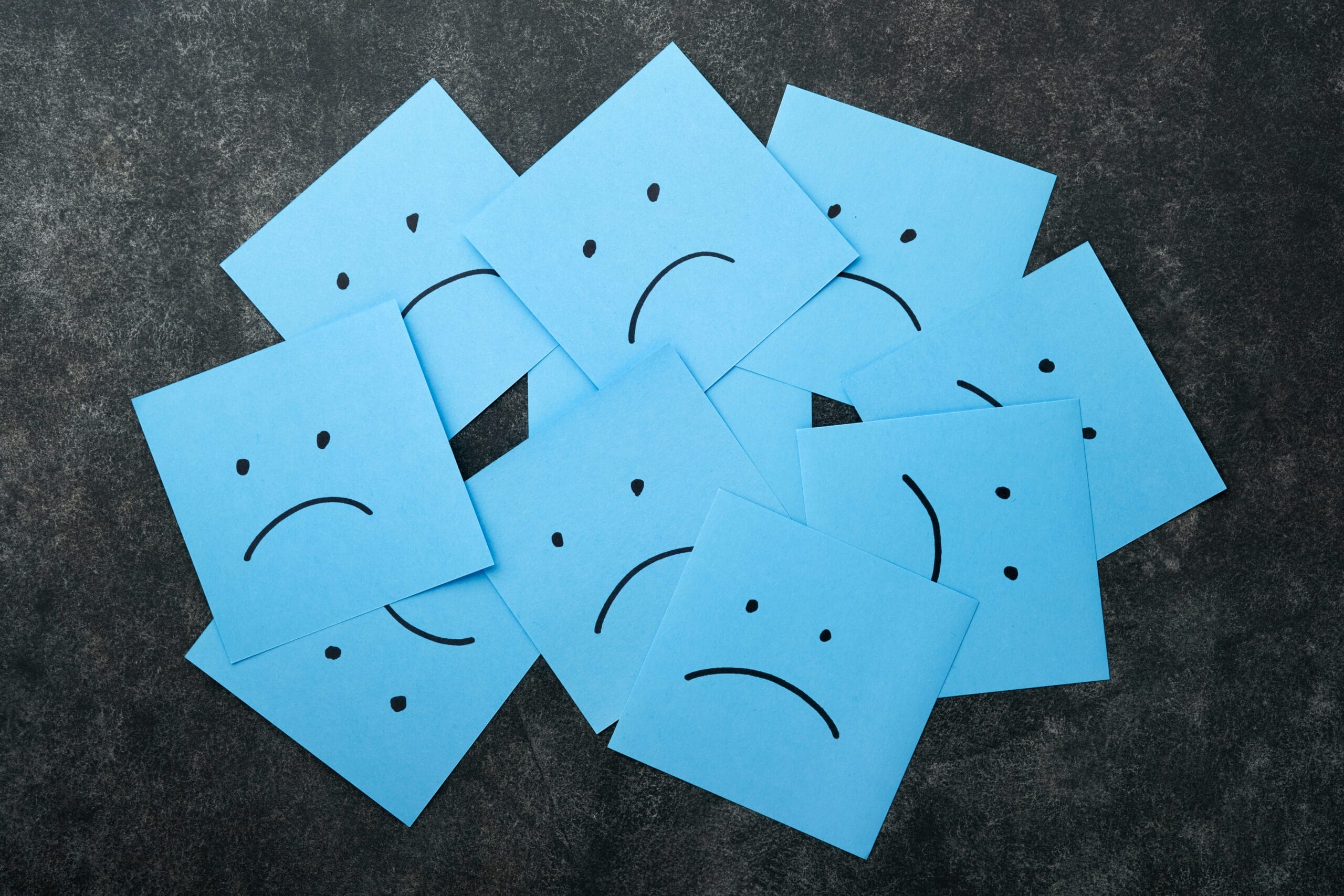 collection of blue sticky notes showing various sad faces illustrating the benefits of mindfulness in embracing the full paradox of emotional range for Houston Willowbrook residents