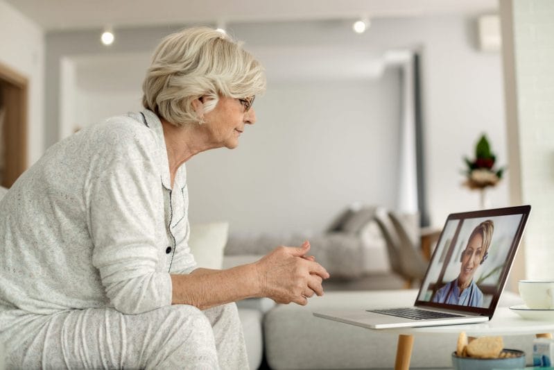 .A senior client engaging in a successful telehealth therapy houston session from home in The Woodlands